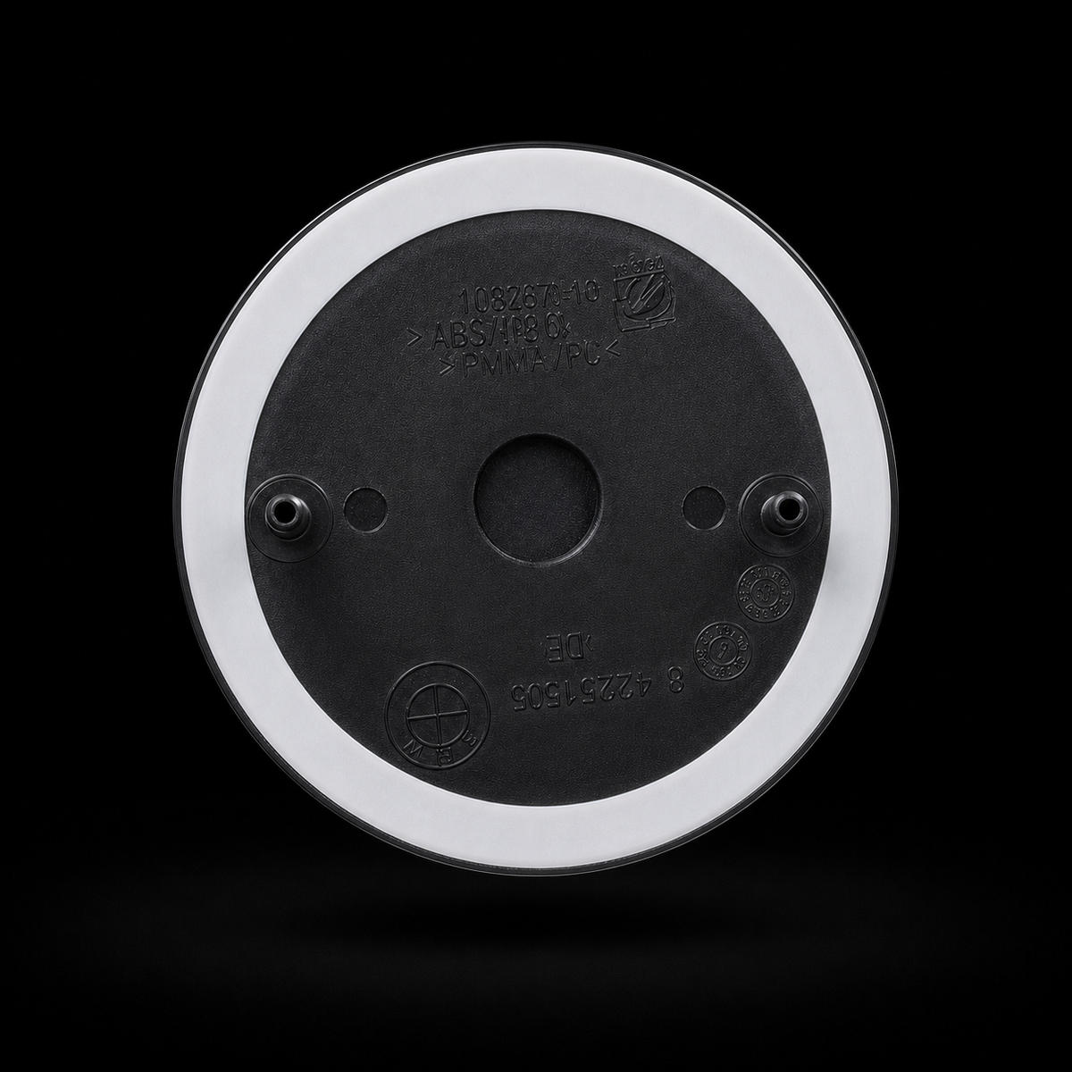 Badge rear view — two mounting pins and double-sided automotive tape ring, no drilling